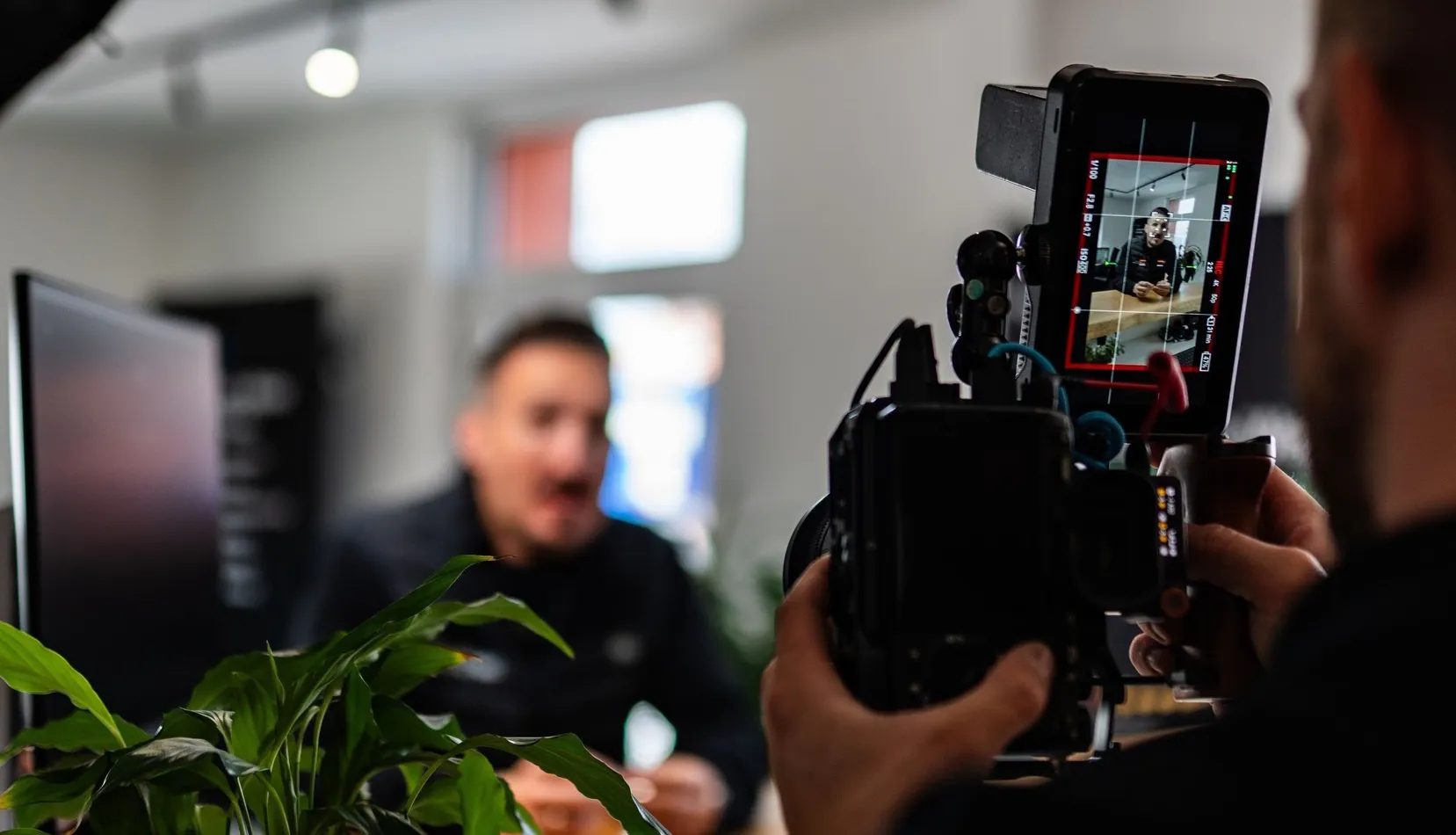Über uns - Behind-the-Scenes Aufnahme eines Videodrehs bei EK4YOU: Kameramann filmt ein Interview in den Büroräumen.